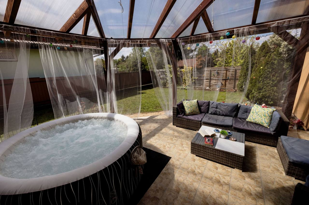 Fedett jacuzzi a teraszon kanapéval